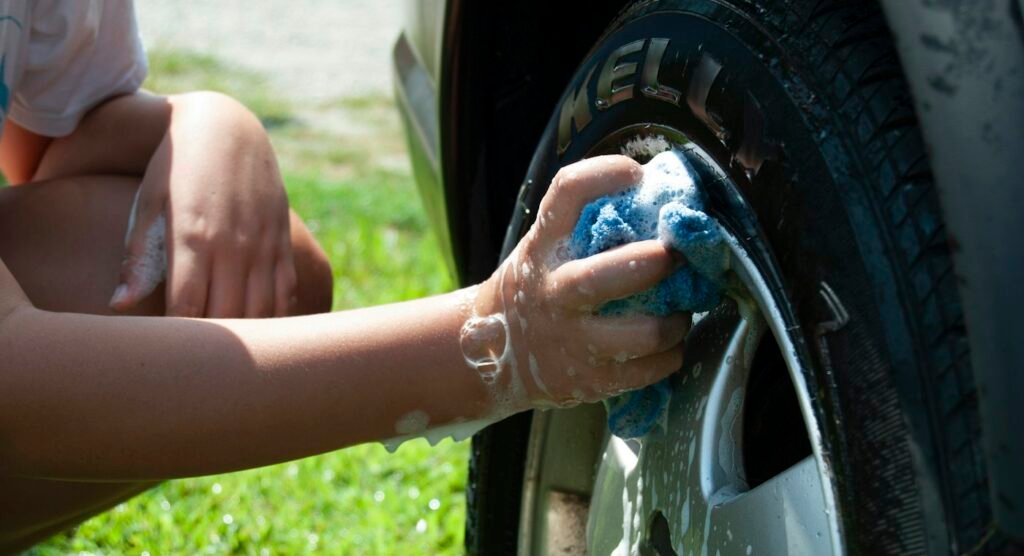 Detailer washing a vehicle tire and wheel
