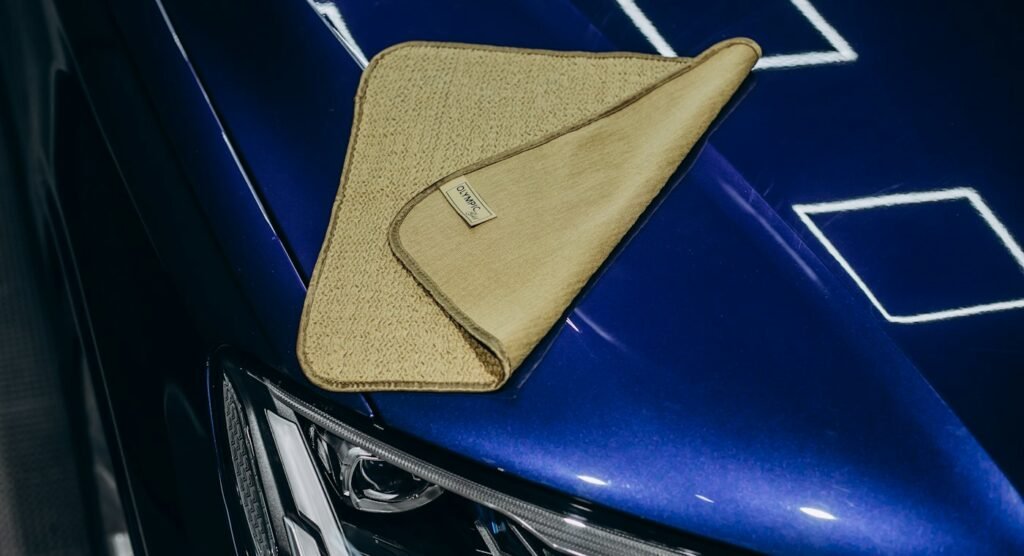 Microfiber cloth resting on a glossy blue car